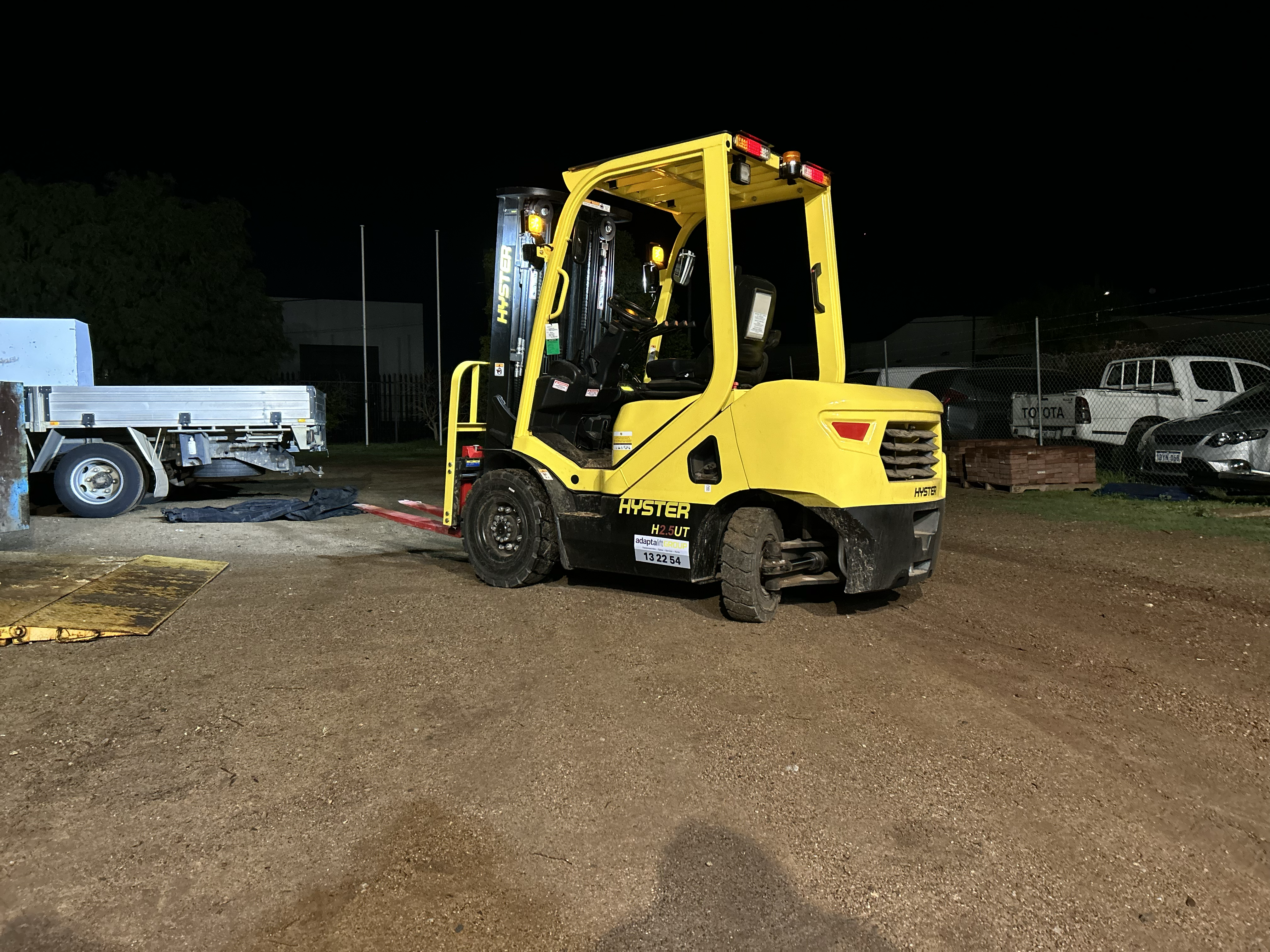 Forklift in trucking yard, connote, transport.